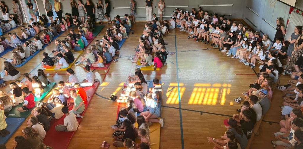 Kinder sitzen im Turnsaal