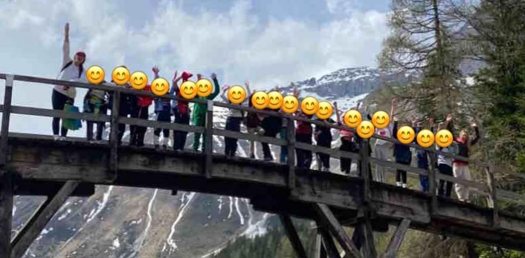 Kinder stehen mit den Lehrpersonen auf einer Brücke