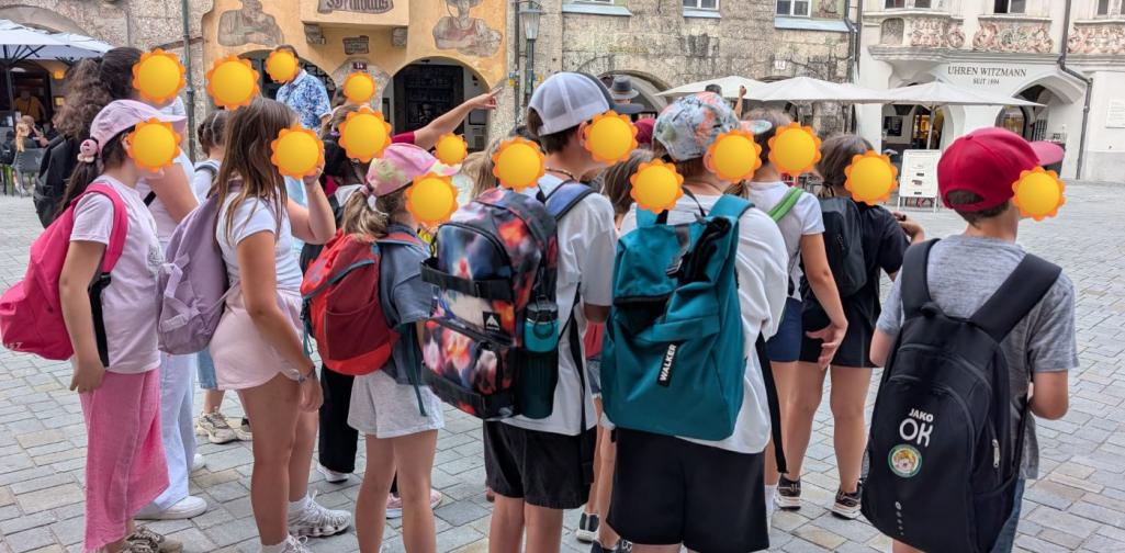 Kinder stehen in der Innsbrucker Altstadt als Gruppe zusammen und schauen alle in eine Richtung