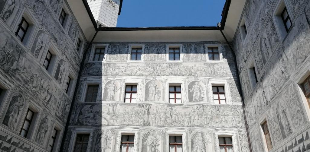 Innenhof von Schloss Ambras mit vielen Fenstern und schönen Wandmalereien