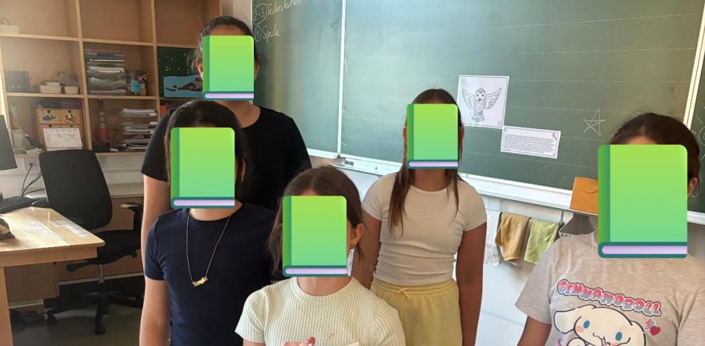 fünf Kinder stehen als Gruppe vor einer Tafel