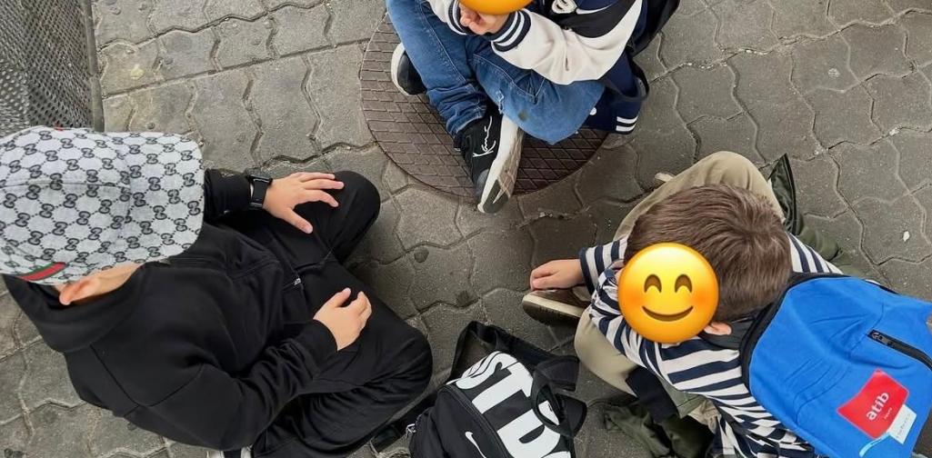 Kinder sitzen am Bahnsteig